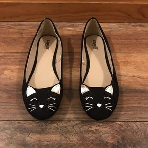 Black ballet flats with a cat face on the toe.